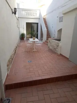 a patio with a table and chairs in a building at Charming traditional family townhouse in Calella in Calella