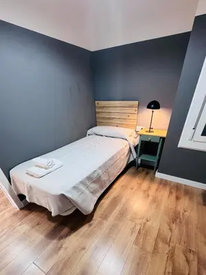 a small bedroom with a bed and a desk at Apartamento Lauda 2 in Hospitalet de Llobregat