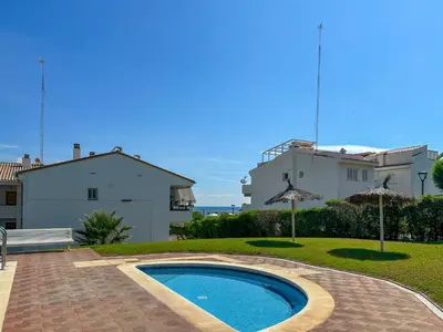 a swimming pool in front of a house at Viva Palms by Hello Homes Sitges in Sitges