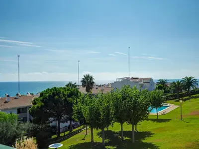 a view of a resort with trees and the ocean at Viva Palms by Hello Homes Sitges in Sitges