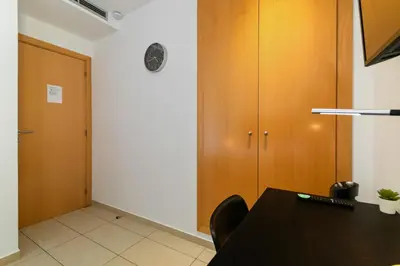 a room with a table and some wooden cabinets at Carol Suites Fira Barcelona Habitaciones privadas en apartamento in Hospitalet de Llobregat