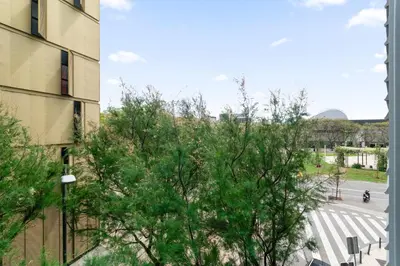 a tree in front of a building and a street at Carol Suites Fira Barcelona Habitaciones privadas en apartamento in Hospitalet de Llobregat