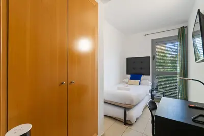 a bedroom with a bed and a desk and a room with a bed at Carol Suites Fira Barcelona Habitaciones privadas en apartamento in Hospitalet de Llobregat