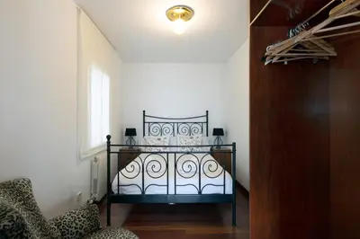 a bedroom with a bed and a chair and a window at Exclusive Villa with Private Pool in Sitges in Sitges