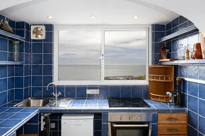 a blue tiled kitchen with a sink and a window at Exclusive Villa with Private Pool in Sitges in Sitges