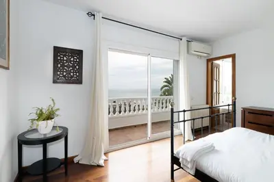 a bedroom with a bed and a view of the ocean at Exclusive Villa with Private Pool in Sitges in Sitges