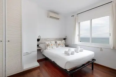 a white bedroom with a large bed with a window at Exclusive Villa with Private Pool in Sitges in Sitges