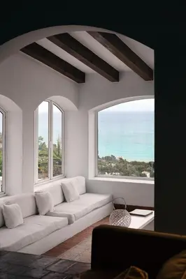 a living room with a couch and two windows at Exclusive Villa with Private Pool in Sitges in Sitges