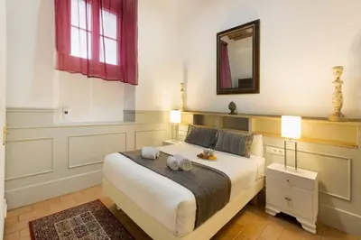 a bedroom with a large white bed with a mirror at Romantic in Trendy Gracia in Barcelona