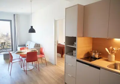 a bedroom with a white bed and a red suitcase at aparto Diagonal Suites in Esplugues de Llobregat