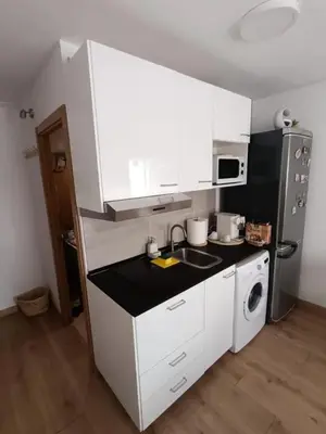 a kitchen with white cabinets and a black counter top at Studio B in Santa Coloma de Gramanet