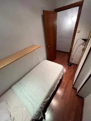 a small bedroom with a bed and a wooden floor at HABITACIÓN barcelona in Barcelona