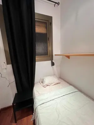 a small bed in a room with a window at HABITACIÓN barcelona in Barcelona