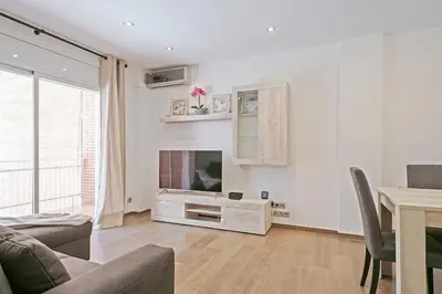 a living room with a tv and a couch and a table at Dialez Holidays - Sant Nicasi in Gavà