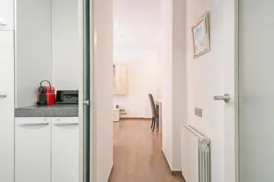 a kitchen with white cabinets and a wooden floor at Dialez Holidays - Sant Nicasi in Gavà