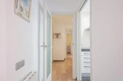 a hallway with white walls and a staircase with a mirror at Dialez Holidays - Sant Nicasi in Gavà