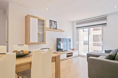 a kitchen and living room with a table and chairs at Dialez Holidays - Colomeres in Gavà