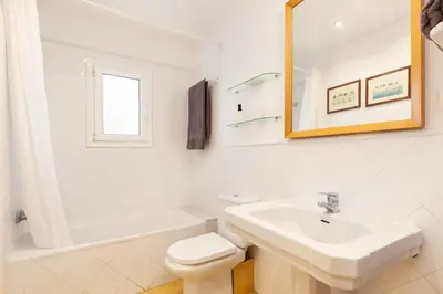 a white bathroom with a sink and a toilet at Casa Rosari I - Jardín & Parking Privado in Vilassar de Mar