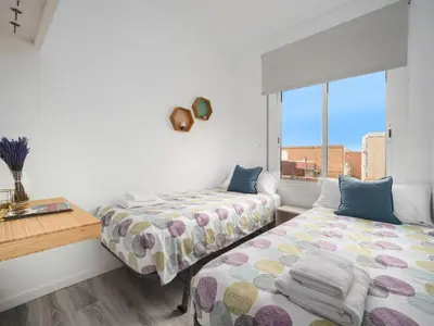 a bedroom with two beds and a window at Cosy Sants Apartment in Barcelona