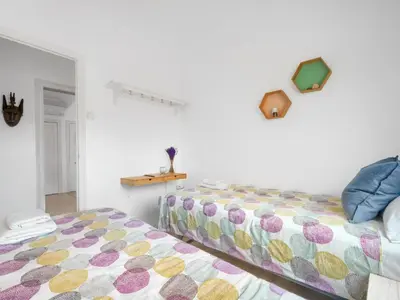 a bedroom with a bed and a white wall at Cosy Sants Apartment in Barcelona