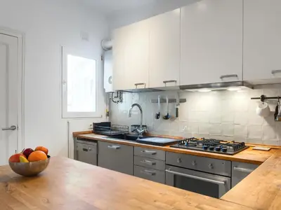 a kitchen with a bowl of fruit on a wooden table at Cosy Sants Apartment in Barcelona