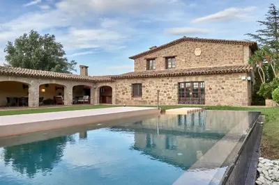 a stone house with a swimming pool in front of it at LuxRural Montserrat | Piscina con Vistas Únicas in Marganell