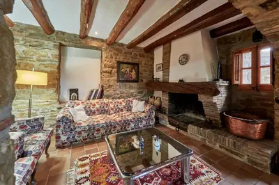 a living room with a couch and a fireplace at LuxRural Montserrat | Piscina con Vistas Únicas in Marganell