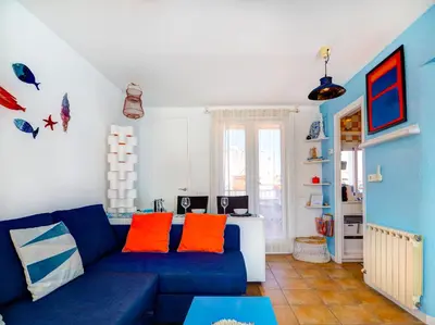 a living room with a blue couch and orange pillows at Las Terracitas Apartment by Hello Homes Sitges in Sitges