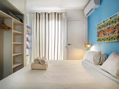 a bedroom with a large white bed with towels on it at Las Terracitas Apartment by Hello Homes Sitges in Sitges