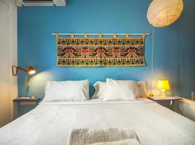 a bedroom with a large white bed with a blue wall at Las Terracitas Apartment by Hello Homes Sitges in Sitges
