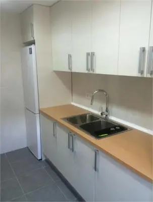 a room with a door and a kitchen with a refrigerator at Bon Casa en Bon Pastor in Barcelona
