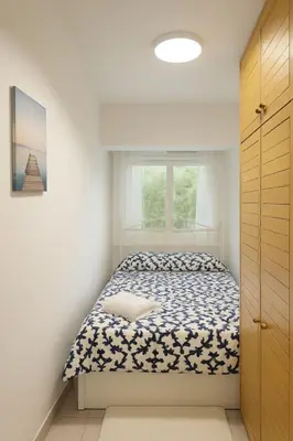 a small bedroom with a bed and a window at New renovate apartment near of the sea in Barcelona