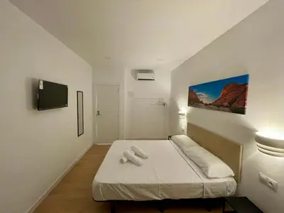 a bedroom with a bed with two towels on it at Lux Hostal in Hospitalet de Llobregat