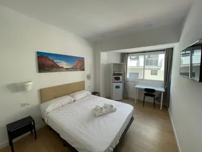 a bedroom with a bed with two white towels on it at Lux Hostal in Hospitalet de Llobregat