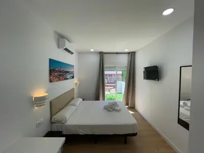 a small bedroom with a bed and a window at Lux Hostal in Hospitalet de Llobregat