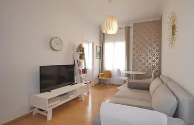 a living room with a couch and a flat screen tv at Modern and Elegant Barcelona Apartment in Barcelona
