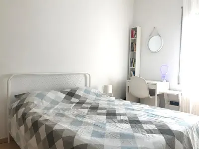 a white bedroom with a bed and a desk at Modern and Elegant Barcelona Apartment in Barcelona