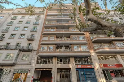 a tall building with a tree in front of it at Sant Joan Design Apartment in Barcelona