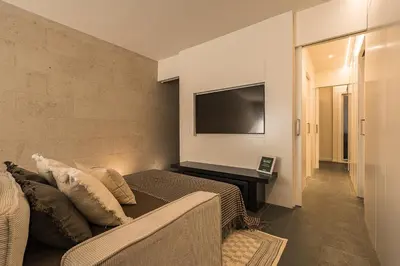a bedroom with a couch and a flat screen tv at Sant Joan Design Apartment in Barcelona