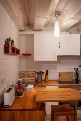 a kitchen with white cabinets and a wooden counter top at Apartment in Ciutat Vella Born in Barcelona