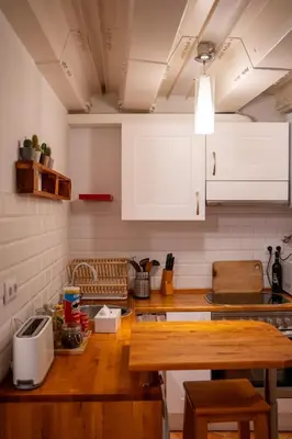 a kitchen with white cabinets and a wooden counter top at Apartment in Ciutat Vella Born in Barcelona