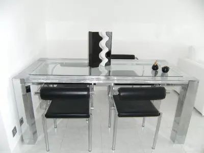 a glass table with black chairs and a glass top at Blanca Subur in Sitges
