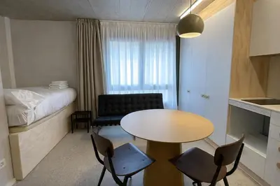 a small room with a table and chairs and a bed at Mooeve Montjuïc in Barcelona