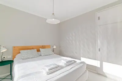 a white bedroom with a bed with towels on it at Marblau Beach Vacation and Downtown Sitges in Sitges