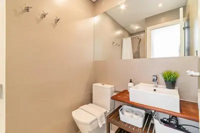 a bathroom with a white toilet and a sink at Marblau Beach Vacation and Downtown Sitges in Sitges