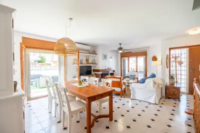 a dining room and living room with a table and chairs at Can Montardo in Sant Pere de Ribes