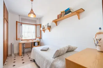 a bedroom with a bed and a desk and a window at Can Montardo in Sant Pere de Ribes