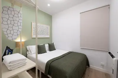 a small bedroom with a bed and a mirror at Stay U-nique Apartment Passeig d´Amunt in Barcelona