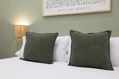 a bed with two pillows and a picture on the wall at Stay U-nique Apartment Passeig d´Amunt in Barcelona