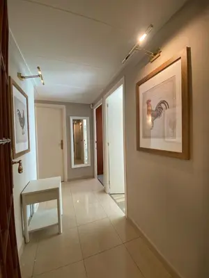 a hallway with a chair and a picture on the wall at Centric Apartment with Balcony in Barcelona